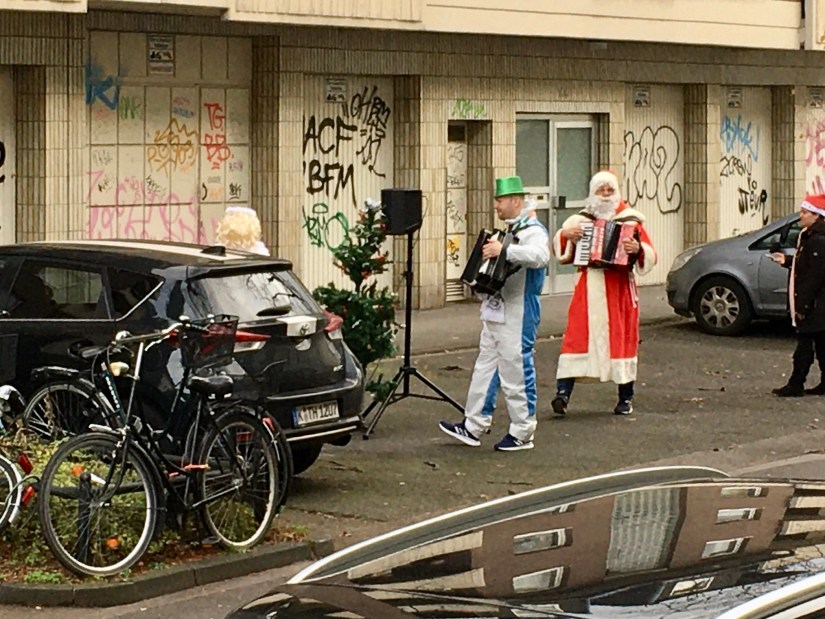 Weihnachtsmann mit Akkordeon auf der Straße.