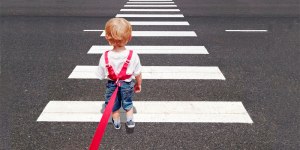 Kleinkind vor Zebrastreifen an pinker Leine.