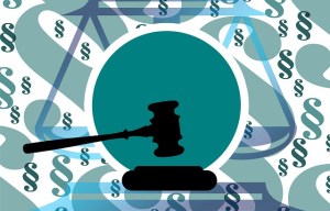 Grafik eines Hammer für die Bekräftigung eines Urteils vor Gericht. Im Hintergrund eine Waage und Paragraphenzeichen. 