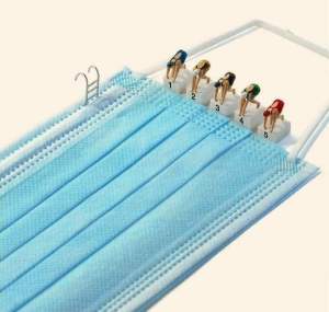 Miniatur-Schwimmerinnen stehen auf Sprungblöcken am Rand einer blauen medizinischen Maske, die wir ein Schwimmbecken aussieht. 