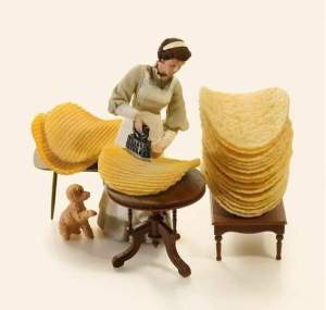 Miniaturfigur bügelt Chips (in Originalgrösse) glatt.