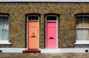 Haus mit zwei bunten Türen nebeneinander.