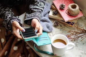 Junge Frau mit Handy in der Hand in weihnachtlicher Umgebung.