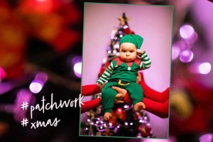 Baby vor Weihnachtsbaum mit grimmigem Gesichtsausdruck