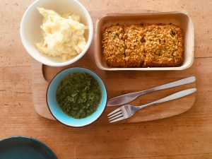 Mittagessen (Fisch, Spinat und Kartoffelpüree) auf Holztisch.