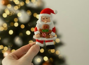 Lebkuchen-Weihnachtsmann vor beleuchtetem Weihnachtsbaum