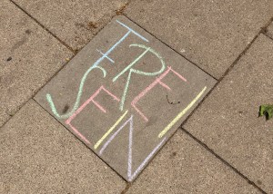 Gehweg, auf dem mit Strassenkreide die Worte „frei sein“ stehen